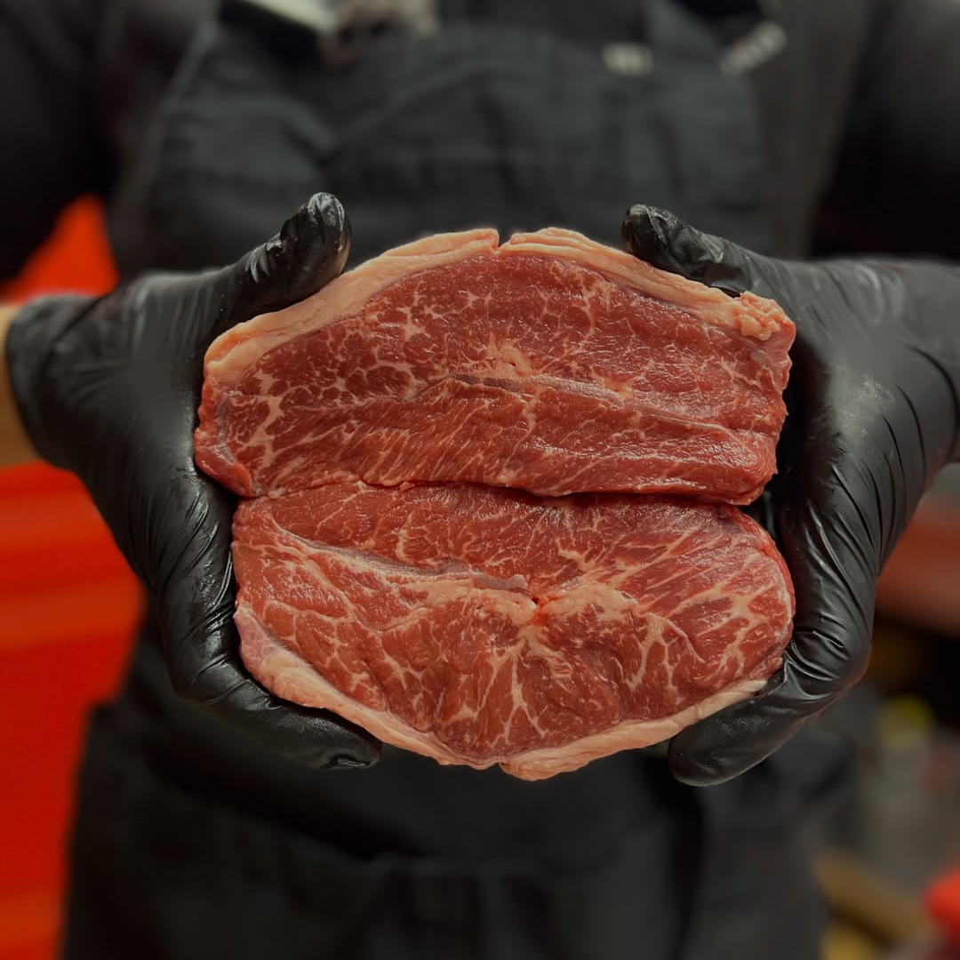 Fresh premium beef steak with rich marbling held by butcher