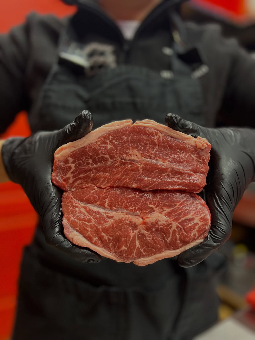 Raw marbled beef steak close-up in butcher hands high quality meat
